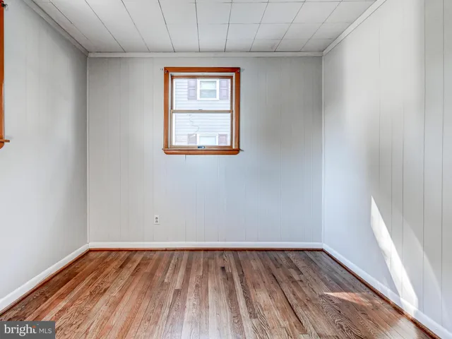 a view of a room with wooden floor and window