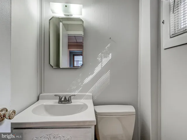 a bathroom with a toilet sink and mirror