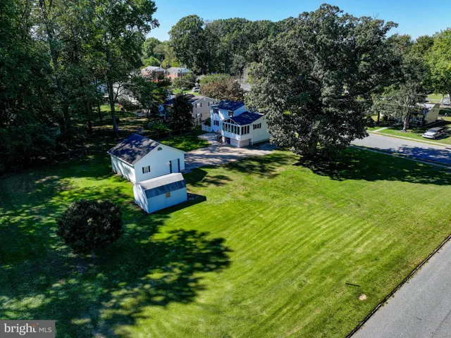 a aerial view of a house with swimming pool a yard and lake view