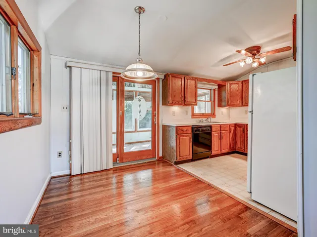 a view of a kitchen with a ceiling fan wooden floor and a kitchen