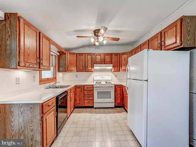 a kitchen with stainless steel appliances granite countertop a stove top oven a refrigerator a sink and dishwasher