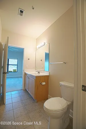 a bathroom with a granite countertop sink a toilet and mirror