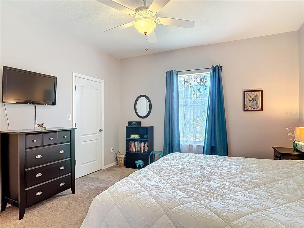 1408 3rd Street Edgewater, FL 32132 - Photo 15 of 43 a bedroom with a bed and a flat tv screen on dresser