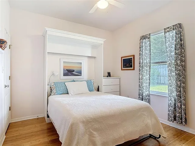 a view of a backyard with a tree and wooden fence