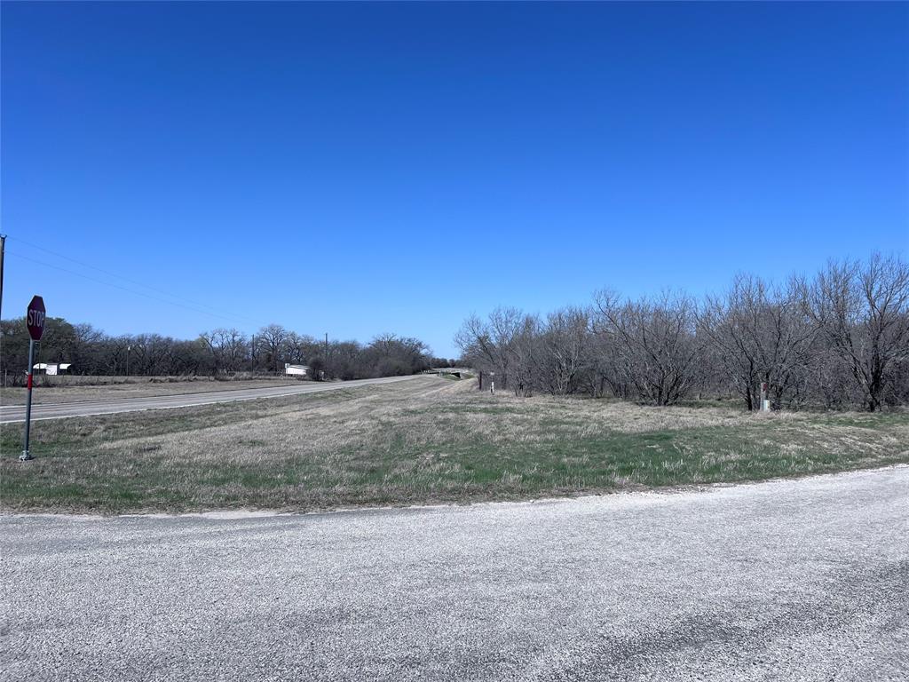 a view of dirt field and trees
