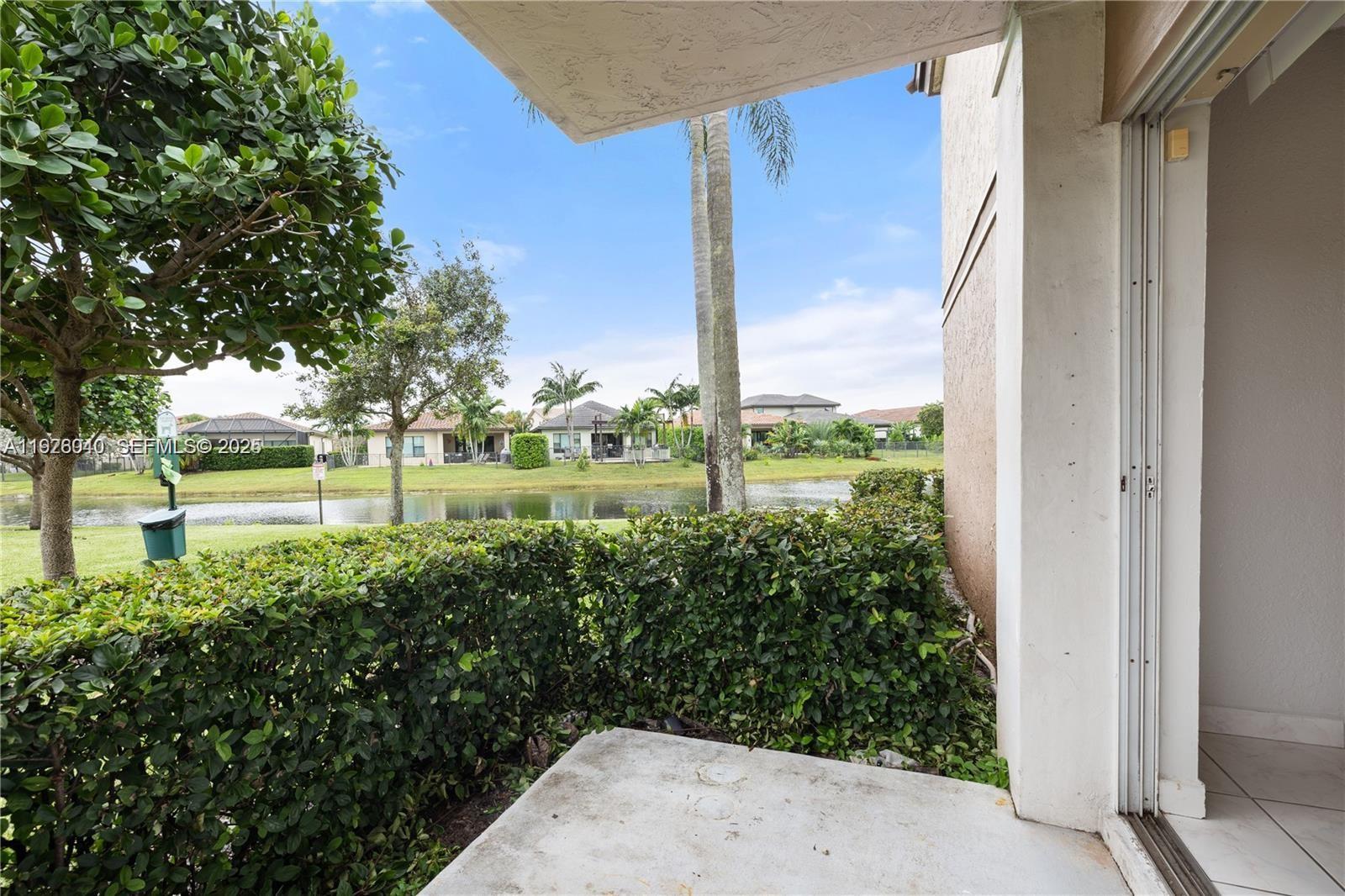1276 Southwest 113th Terrace, Unit 101 Pembroke Pines, FL 33025 - Photo 11 of 18 a view of a garden with plants and large trees