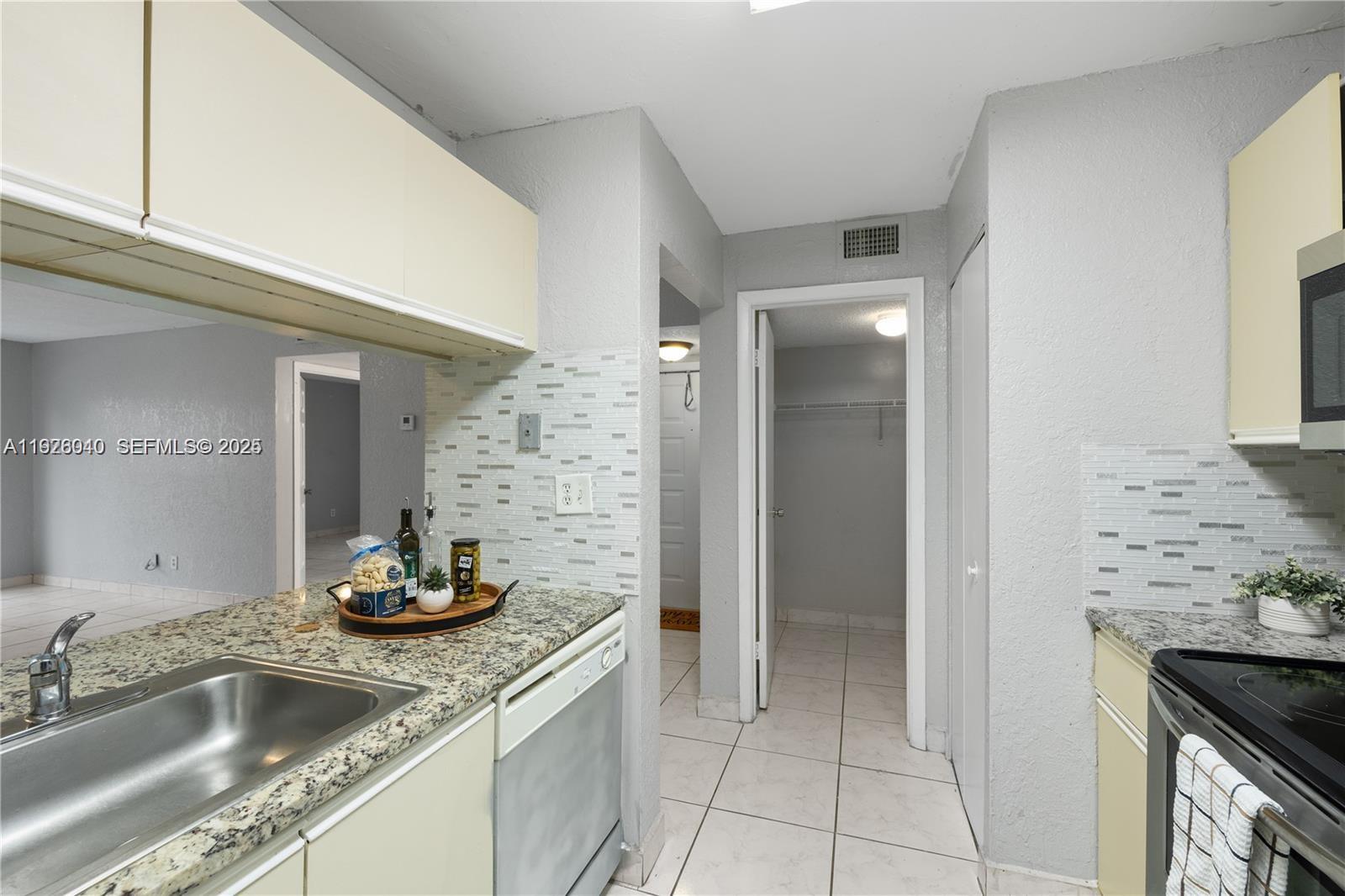 1276 Southwest 113th Terrace, Unit 101 Pembroke Pines, FL 33025 - Photo 8 of 18 a kitchen with stainless steel appliances granite countertop a sink and cabinets