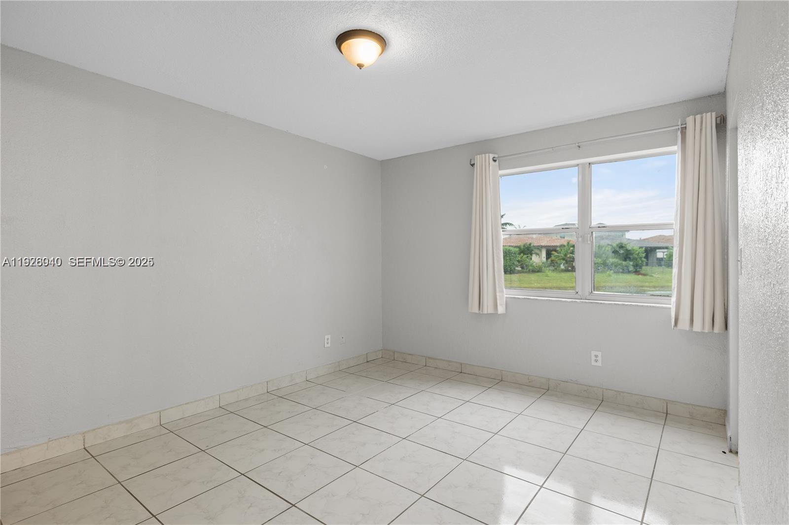 1276 Southwest 113th Terrace, Unit 101 Pembroke Pines, FL 33025 - Photo 9 of 18 an empty room with windows