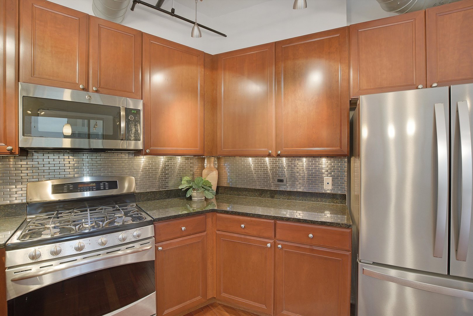 520 South State Street, Unit 510 Chicago, IL 60605 - Photo 13 of 34 a kitchen with stainless steel appliances granite countertop a refrigerator a stove and a sink with wooden cabinets