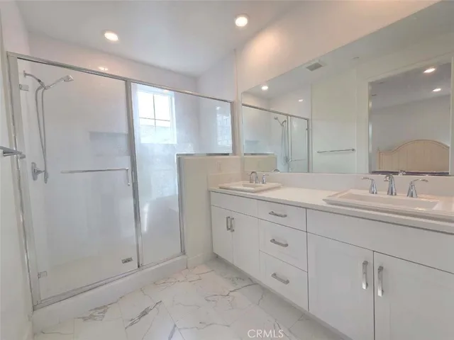 a bathroom with a granite countertop sink a mirror and a shower