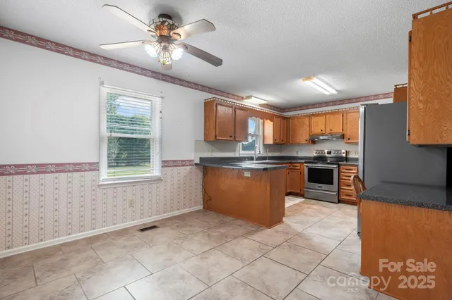 a kitchen with stainless steel appliances granite countertop a stove sink and cabinets
