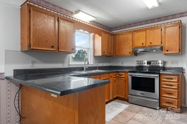 a kitchen with stainless steel appliances granite countertop a sink stove and cabinets