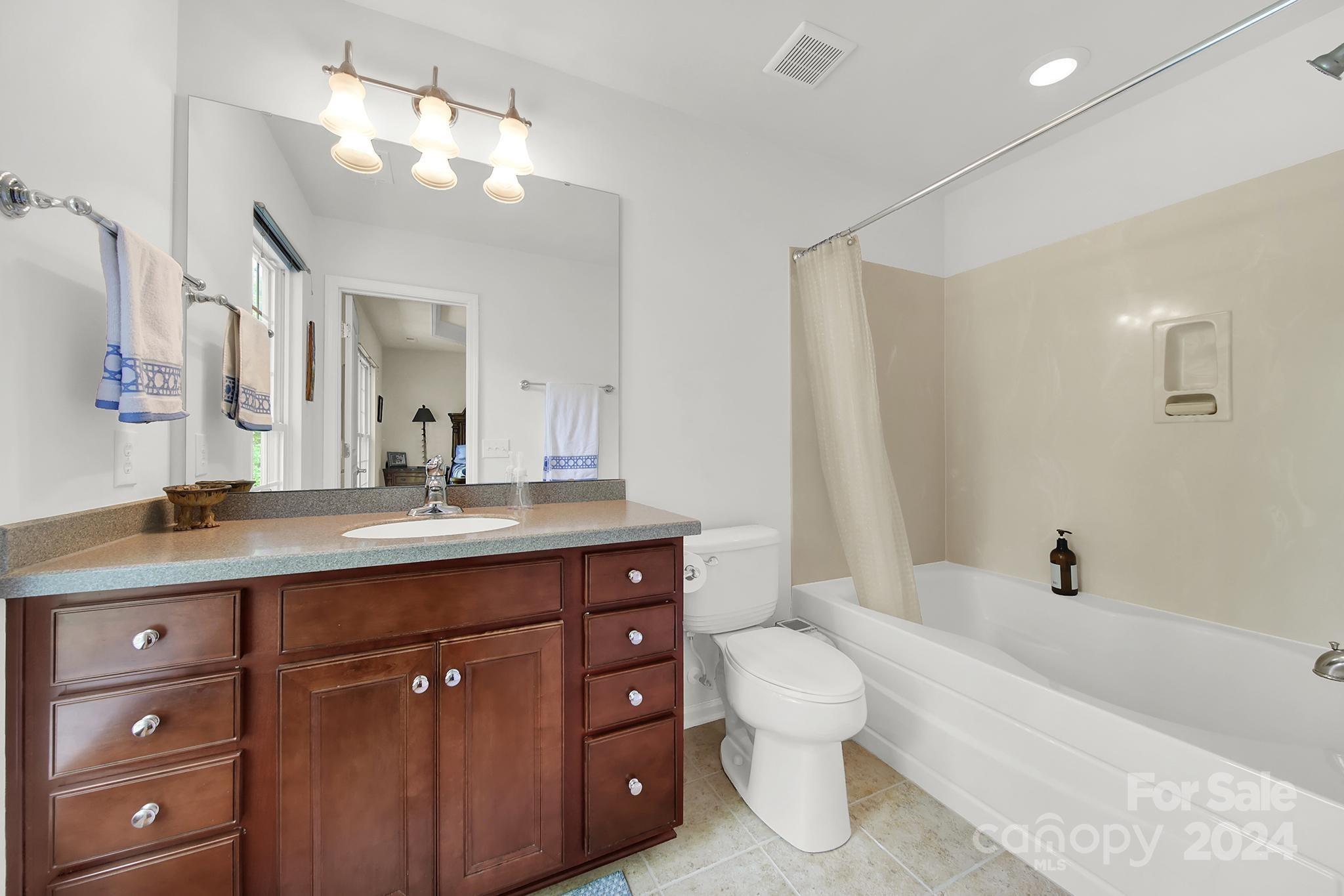 1074 Drayton Court Fort Mill, SC 29708 - Photo 19 of 37 a spacious bathroom with a granite countertop toilet a double vanity sink a mirror and a bathtub