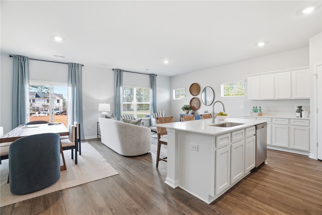 331 Lilac Loop Greenwood, SC 29646 - Photo 13 of 27 This bright, open-concept living space integrates a modern kitchen, dining area, and comfortable living room.