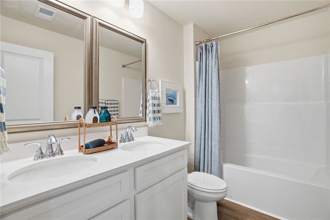 331 Lilac Loop Greenwood, SC 29646 - Photo 24 of 27 This bathroom features a double vanity and a shower-tub combination, creating a functional space.