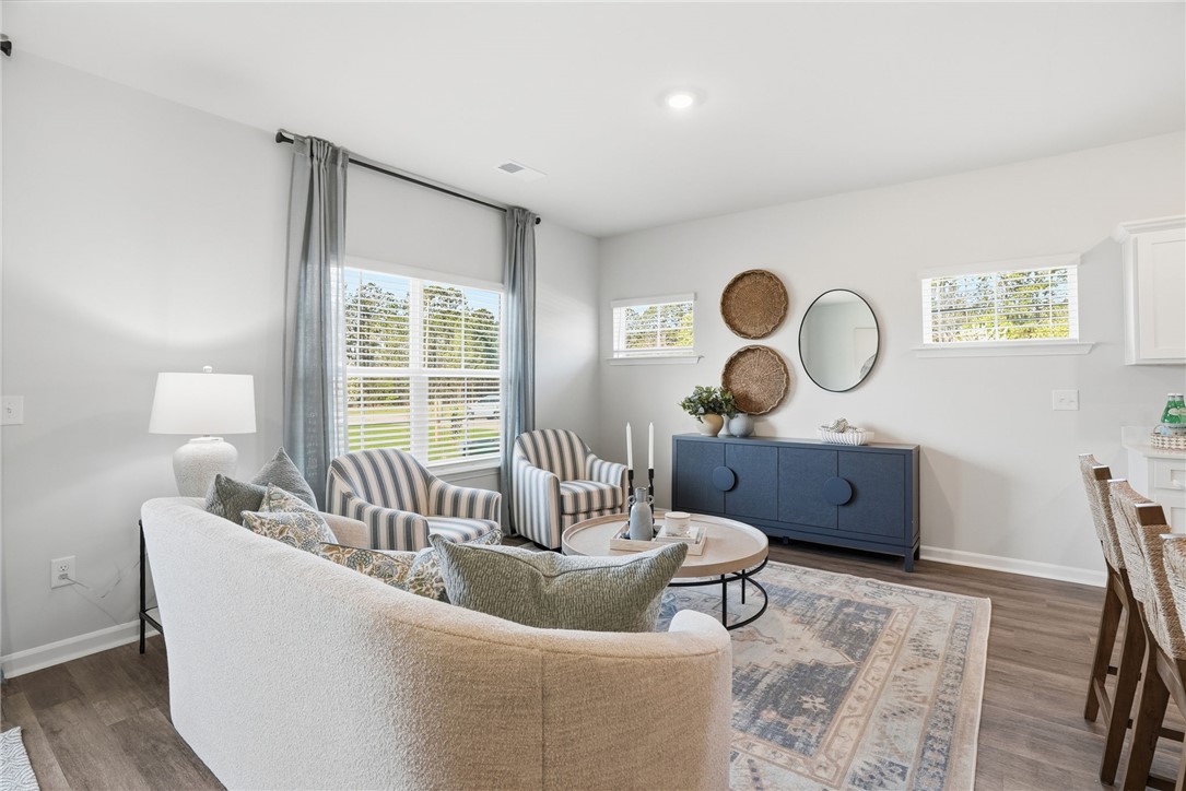 331 Lilac Loop Greenwood, SC 29646 - Photo 6 of 27 This living area features ample natural light and durable flooring, creating a comfortable and inviting atmosphere.