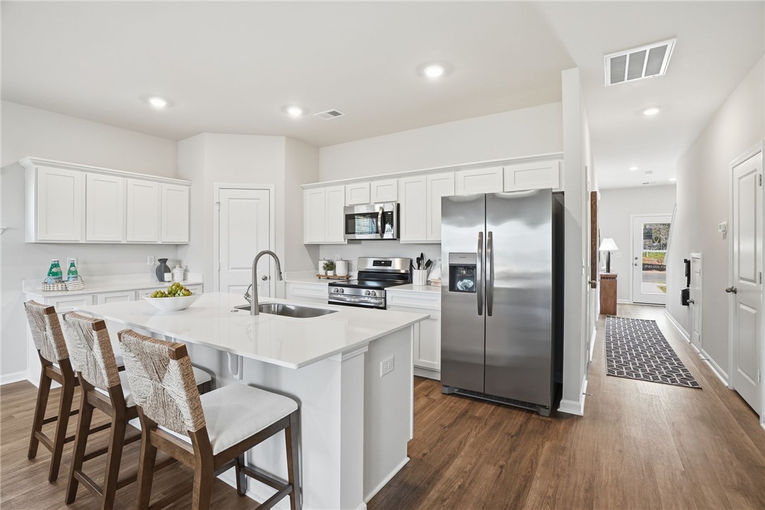 331 Lilac Loop Greenwood, SC 29646 - Photo 8 of 27 This modern kitchen features a spacious island and gleaming stainless steel appliances.