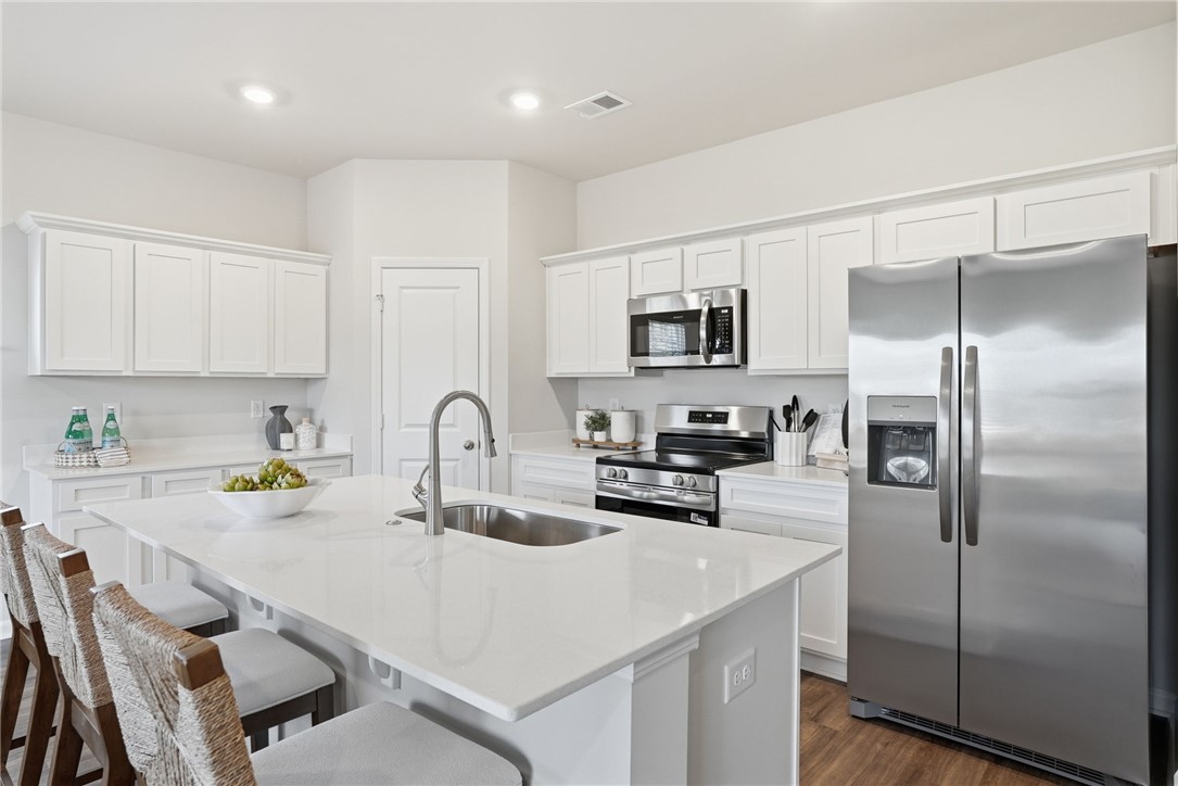 331 Lilac Loop Greenwood, SC 29646 - Photo 9 of 27 This bright kitchen features an island, stainless steel appliances, and sleek white cabinetry.