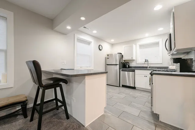 a kitchen with cabinets and chairs