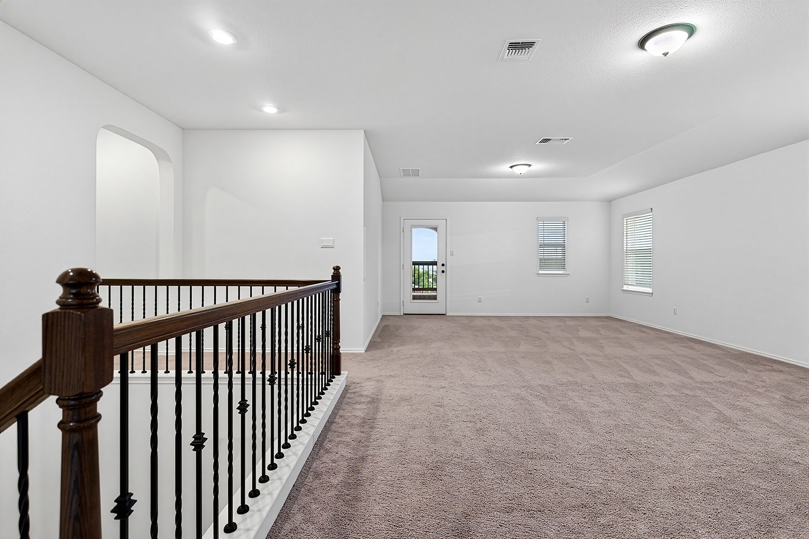 4600 Ercolano Lane Round Rock, TX 78665 - Photo 24 of 37 Spacious upper-level room featuring plush carpeting, multiple windows with blinds, and a door leading to a balcony