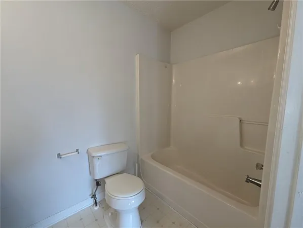 a white toilet sitting next to a bath tub