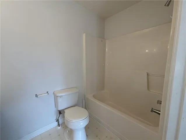 a white toilet sitting next to a bath tub