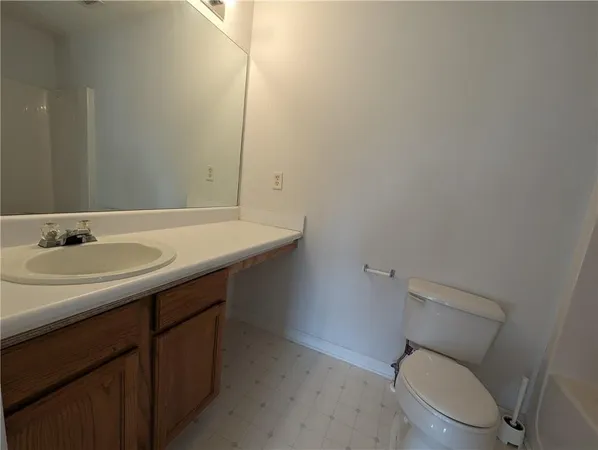 a bathroom with a sink toilet and a mirror
