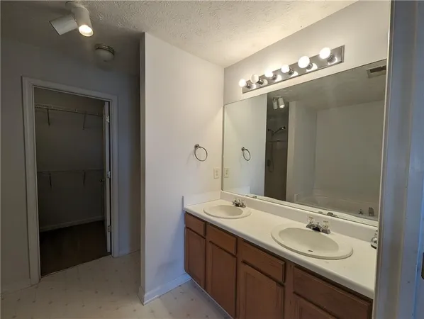 a bathroom with double vanity sinks and a mirror