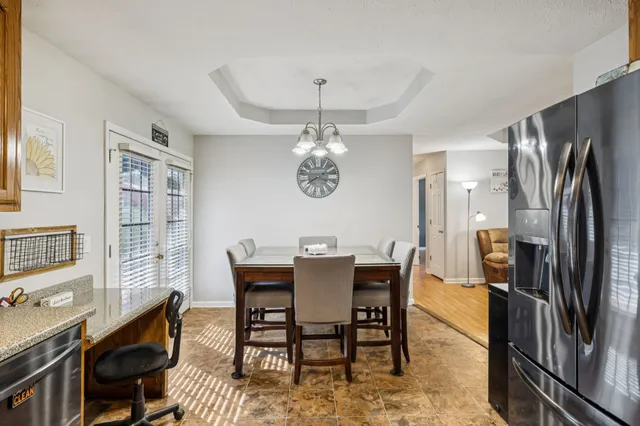 a dining room with furniture a chandelier and wooden floor