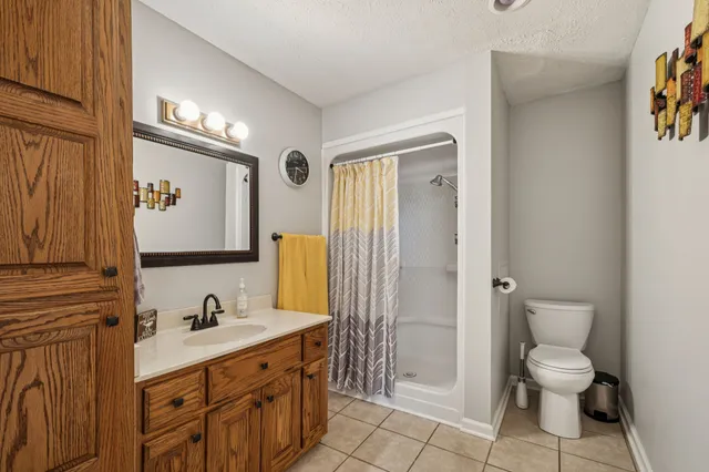 a spacious bathroom with a double vanity sink a mirror and a toilet