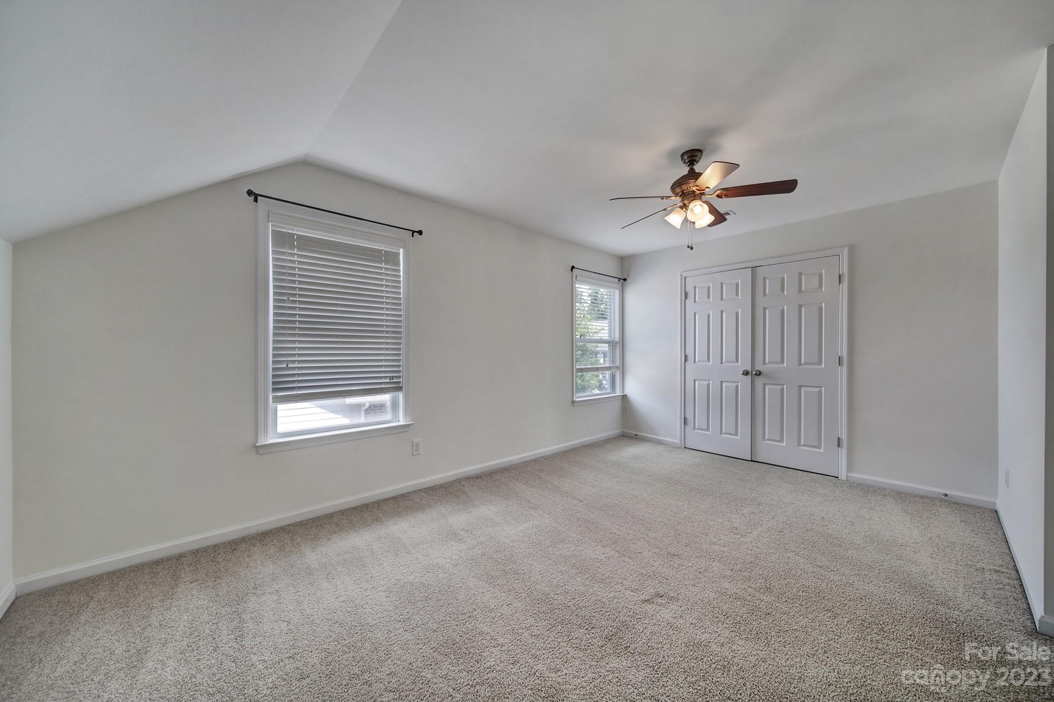 3359 Mandrake Court Tega Cay, SC 29708 - Photo 15 of 33 an empty room with windows and chandelier fan