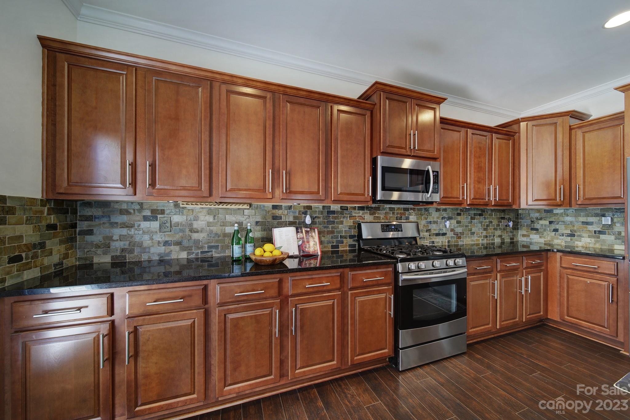 3359 Mandrake Court Tega Cay, SC 29708 - Photo 7 of 33 a kitchen with stainless steel appliances granite countertop a stove a sink dishwasher and a microwave