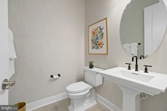 a bathroom with a sink mirror and toilet