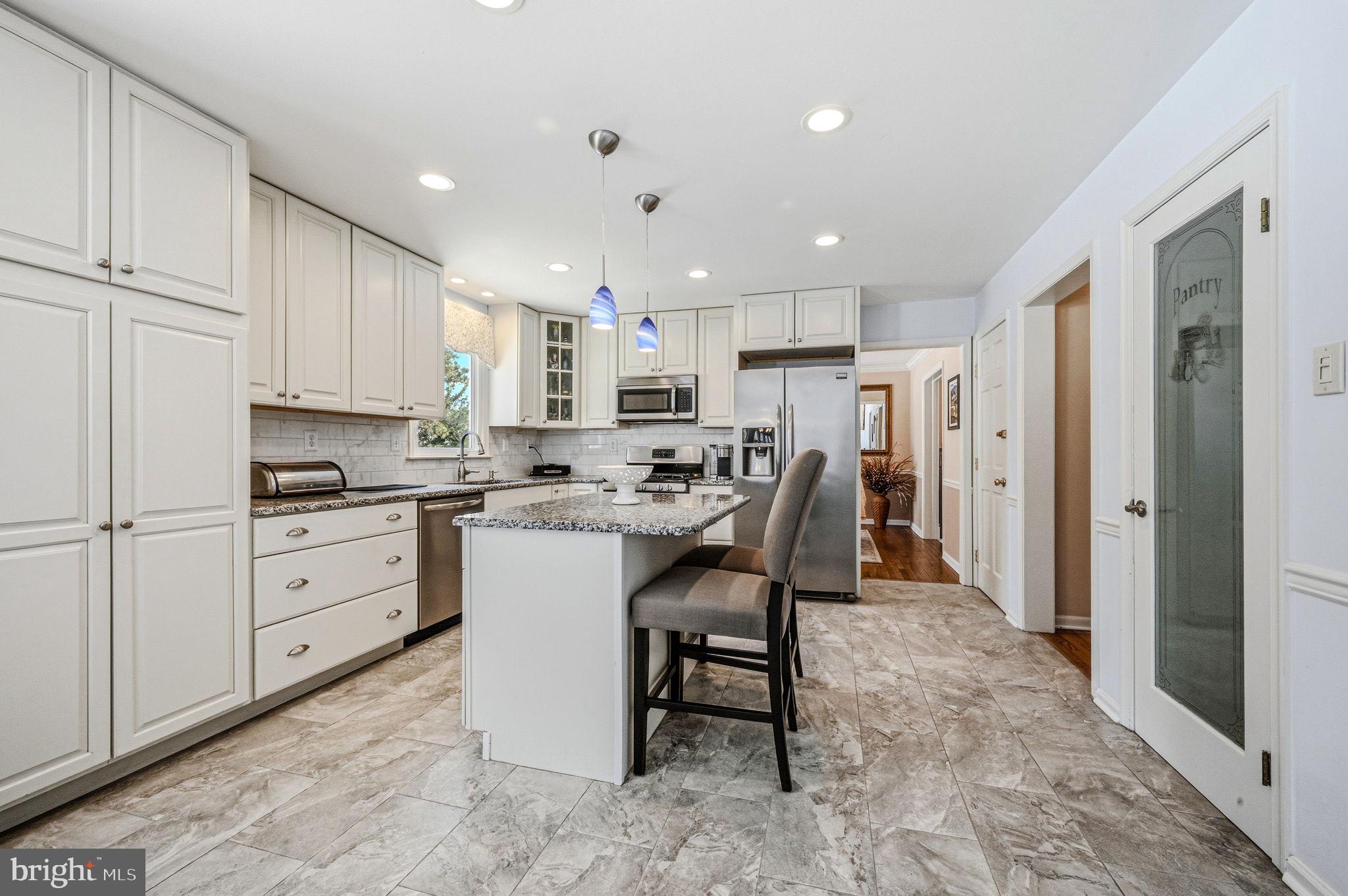 10 Auspice Circle Newark, DE 19711 - Photo 13 of 42 a kitchen with kitchen island a stove a sink a refrigerator and white cabinets