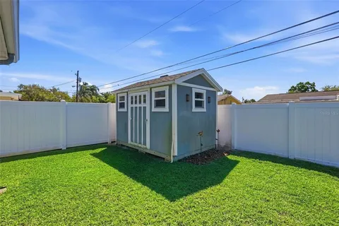 a view of a backyard with potted plants and large tree