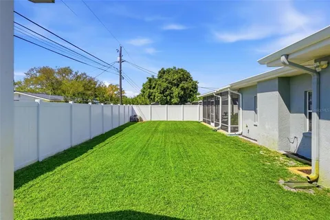 a view of a backyard with plants and wooden fence