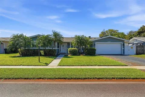 a view of a house with a big yard and large trees