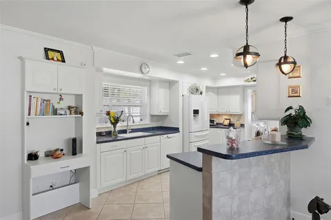 a kitchen with kitchen island white cabinets and refrigerator