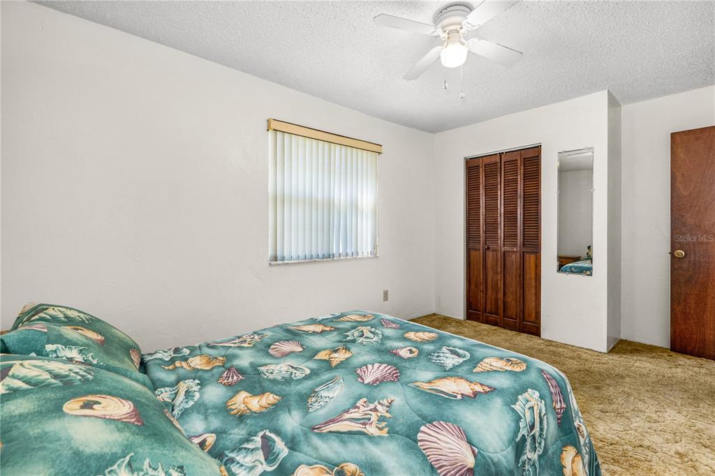 693 Reillys Road Port Orange, FL 32127 - Photo 23 of 31 a bedroom with a bed and a chandelier