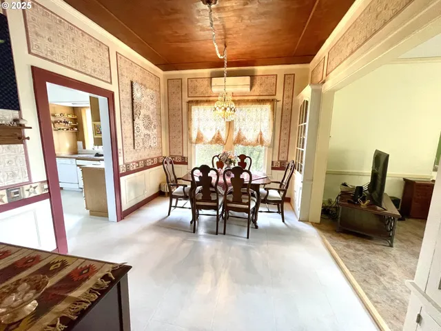a dining room with furniture a chandelier and wooden floor