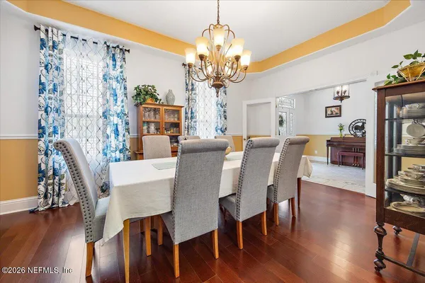 a view of a dining room with furniture wooden floor and chandelier
