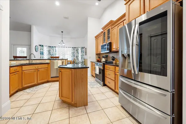 a kitchen with stainless steel appliances granite countertop a stove a sink and a refrigerator