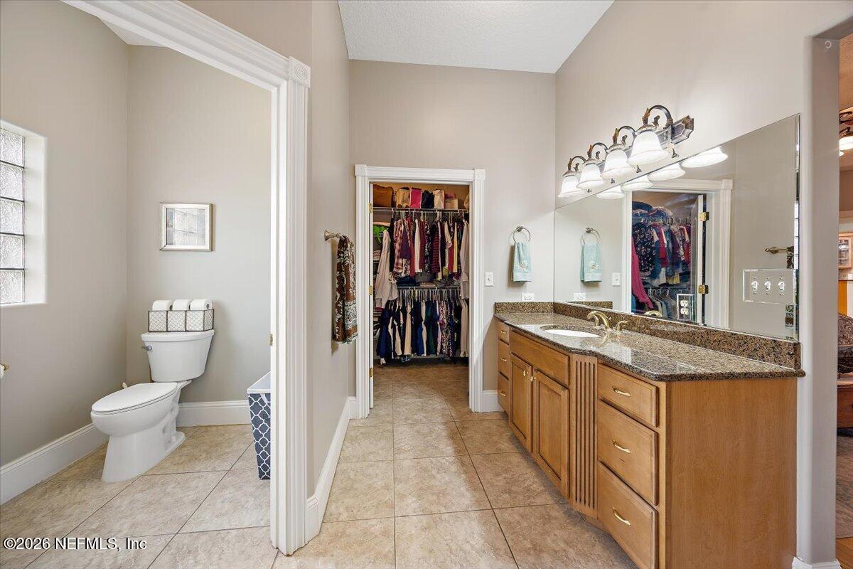 14394 Bob Burnsed Road Glen St. Mary, FL 32040 - Photo 19 of 53 a bathroom with a granite countertop sink a toilet and a mirror