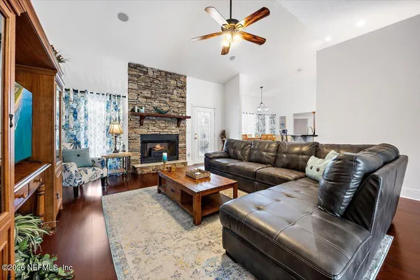a living room with furniture a fireplace and a flat screen tv