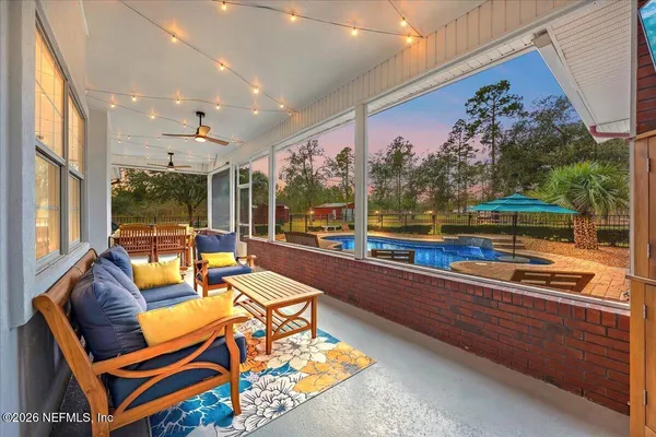 a living room with patio furniture and a floor to ceiling window