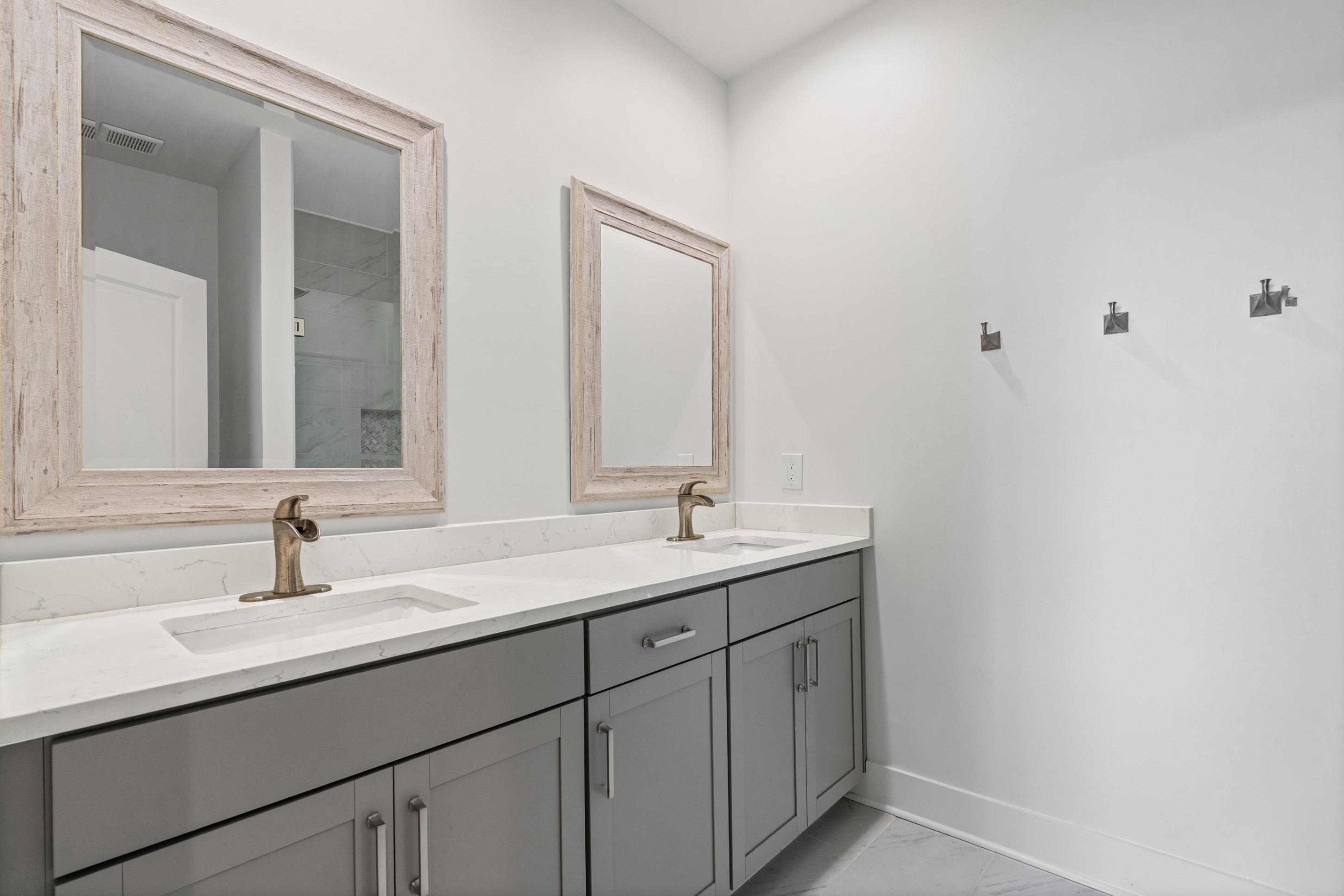620 Diffee Road Moscow, TN 38057 - Photo 14 of 25 Dual vanity with gray cabinetry, white countertops, and bronze-finish faucets