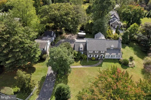 an aerial view of a house with a garden and lake view