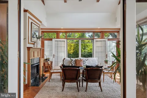 a living room with furniture a fireplace and a large window