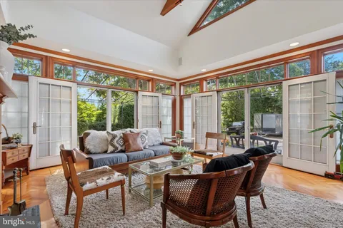 a kitchen with stainless steel appliances a refrigerator a stove a dining table and chairs with wooden floor