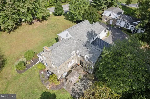 an aerial view of residential house with outdoor space and trees all around